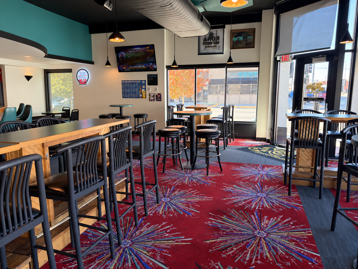 High-top tables and stools beside The Monte’s front windows and entrance