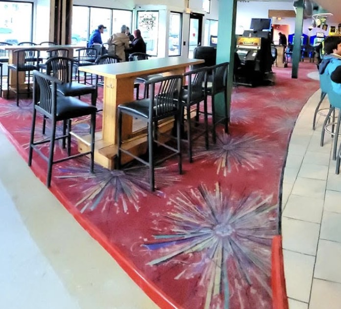 Inside The Monte: high-top tables on burgundy starburst carpet beside the curved bar